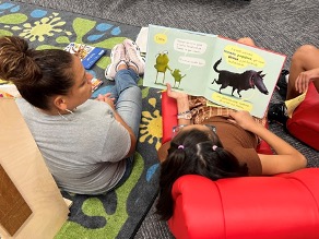 A student reads aloud in Spanish to the teacher and another student.